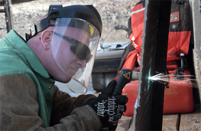 Petty Officer 2nd Class Patrick Moran conducts maintenance on the U.S. Coast Guard Cutter Kanawha in 2006